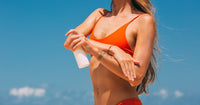Femme appliquant de la crème solaire sur la peau - protection SPF visage